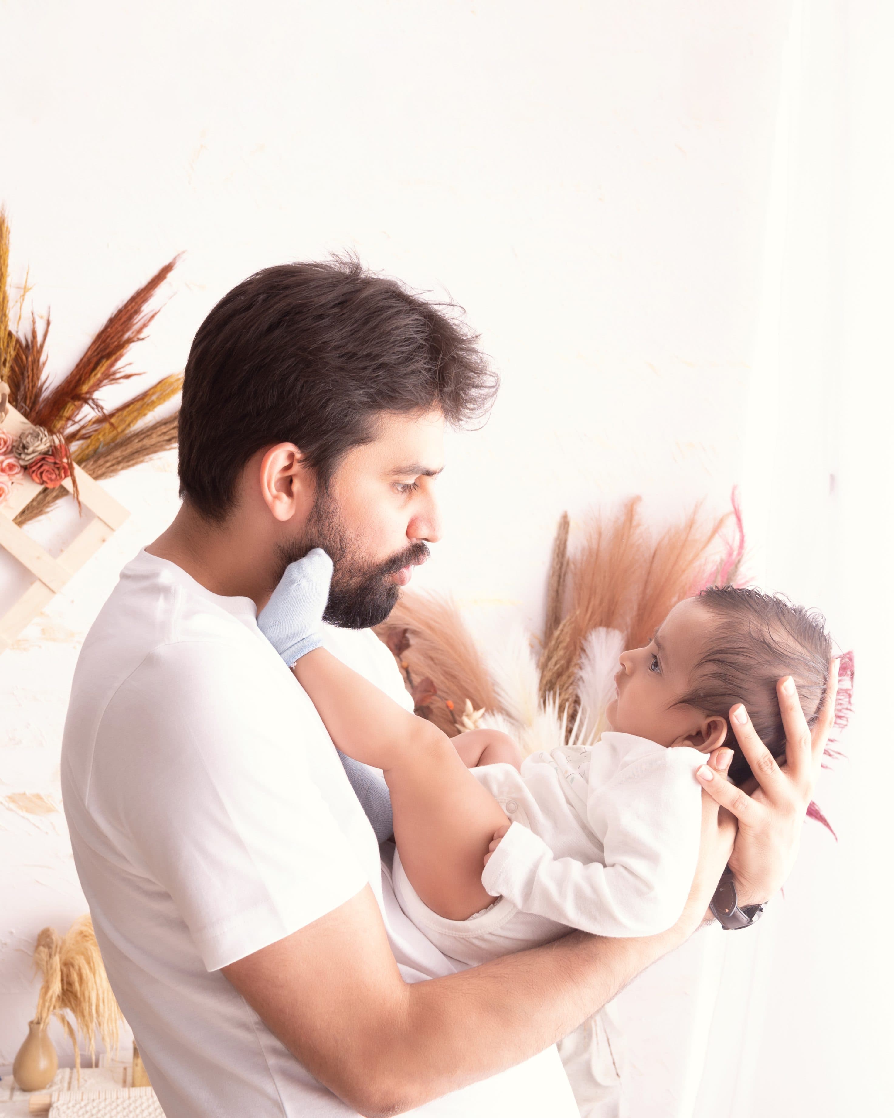 A tender moment between a father and his newborn baby during a professional photoshoot in Delhi NCR by Priyansh Bhardwaj.